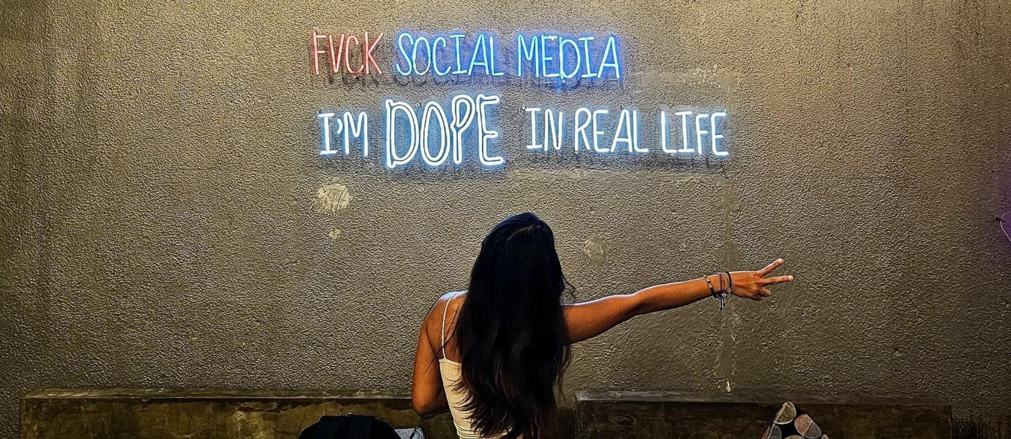 A Pousada Stellar Capsules Seminyak Exterior foto A woman in front of a neon sign